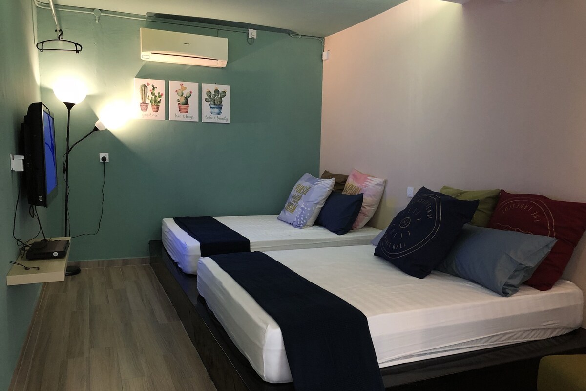 Une chambre avec deux lits, une télévision et la climatisation.