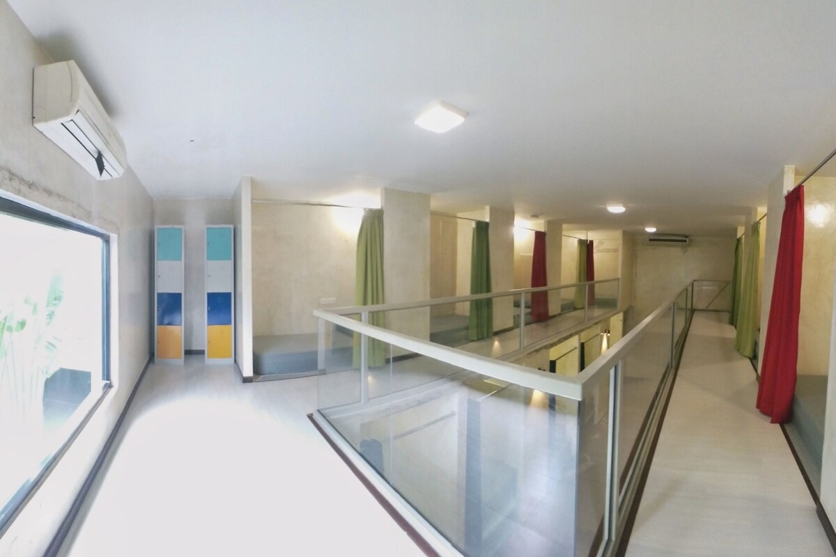 Un intérieur moderne avec une balustrade en verre, un escalier et une vue sur un bâtiment à l’extérieur.