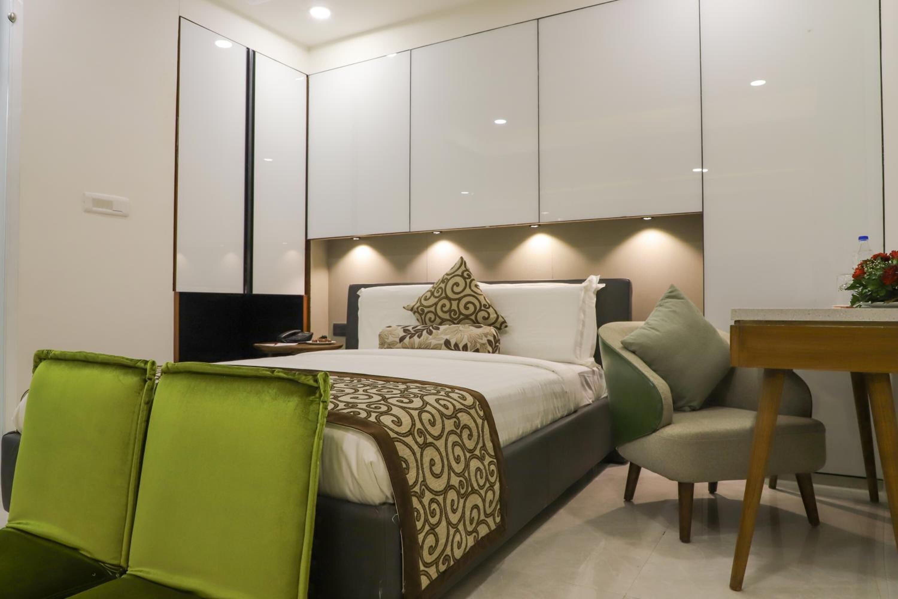 A modern bedroom with a bed, a desk, and a chair.