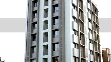 A modern multi-story building with balconies, large windows, and a flat facade.