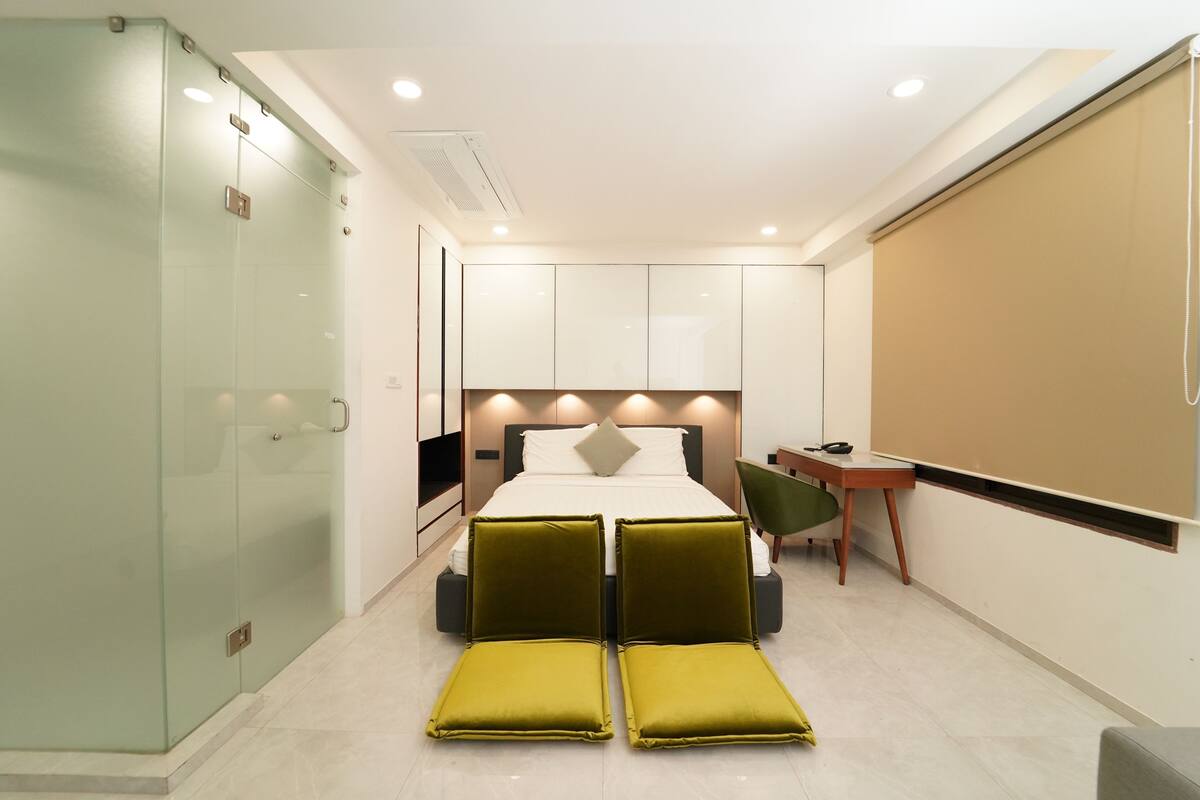 Una habitación de hotel moderna con una cama, un escritorio y una silla.