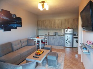 Deluxe-Apartment, Strandblick | Wohnzimmer | Flachbildfernseher, Kamin, Fußbodenheizung