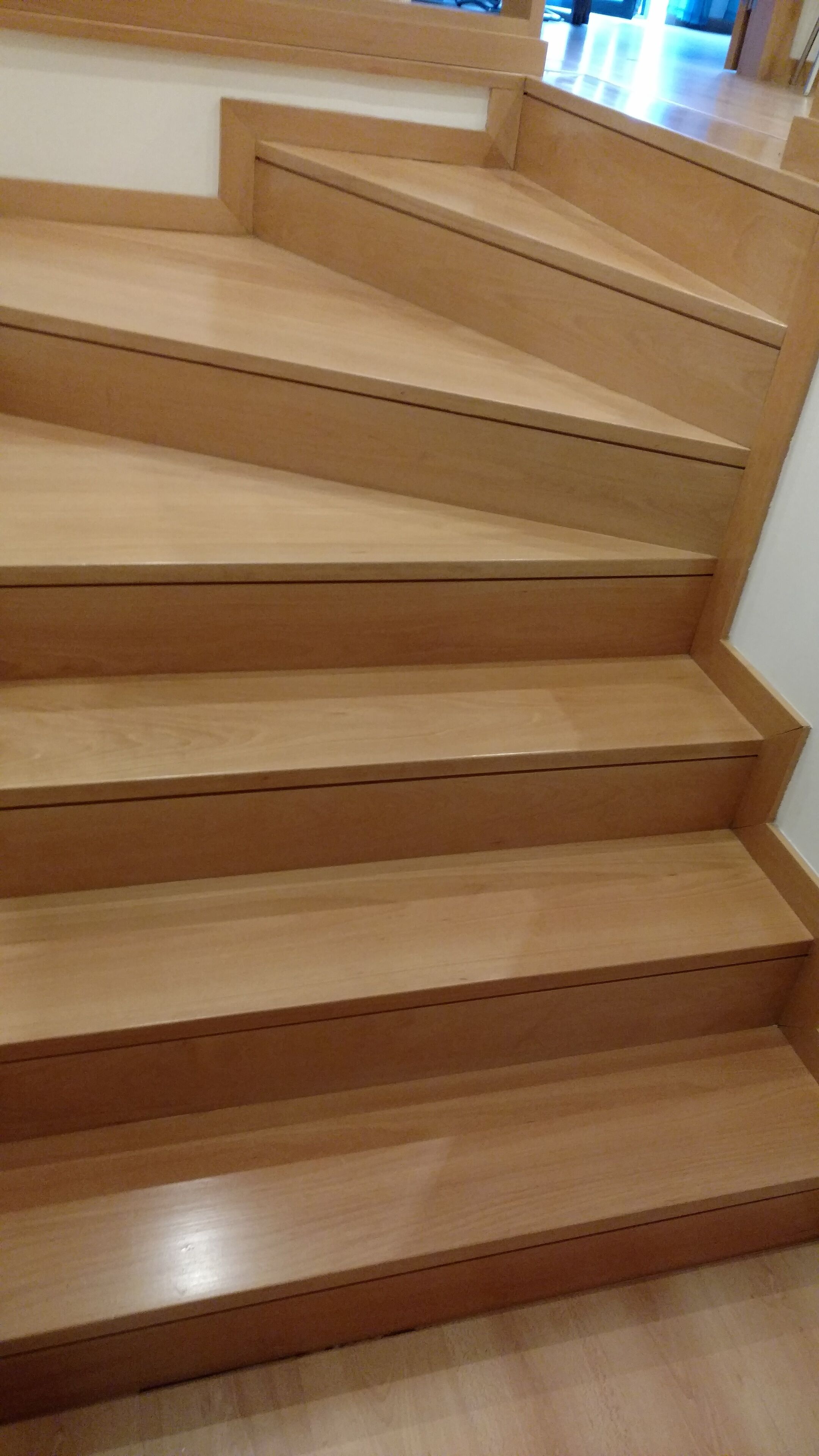 Un escalier en bois, doté d’une rampe, menant à l’étage supérieur.