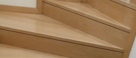 Un escalier en bois, doté d’une rampe, menant à l’étage supérieur.