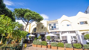 A building with outdoor seating and a tree in front. - Cubo's Apartamento Doña Lola / communal swimming pool / free wifi / near beach (La Cala de Mijas)