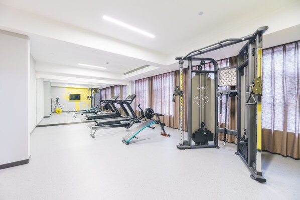 A gym with treadmills, weight machines, and a rowing machine.