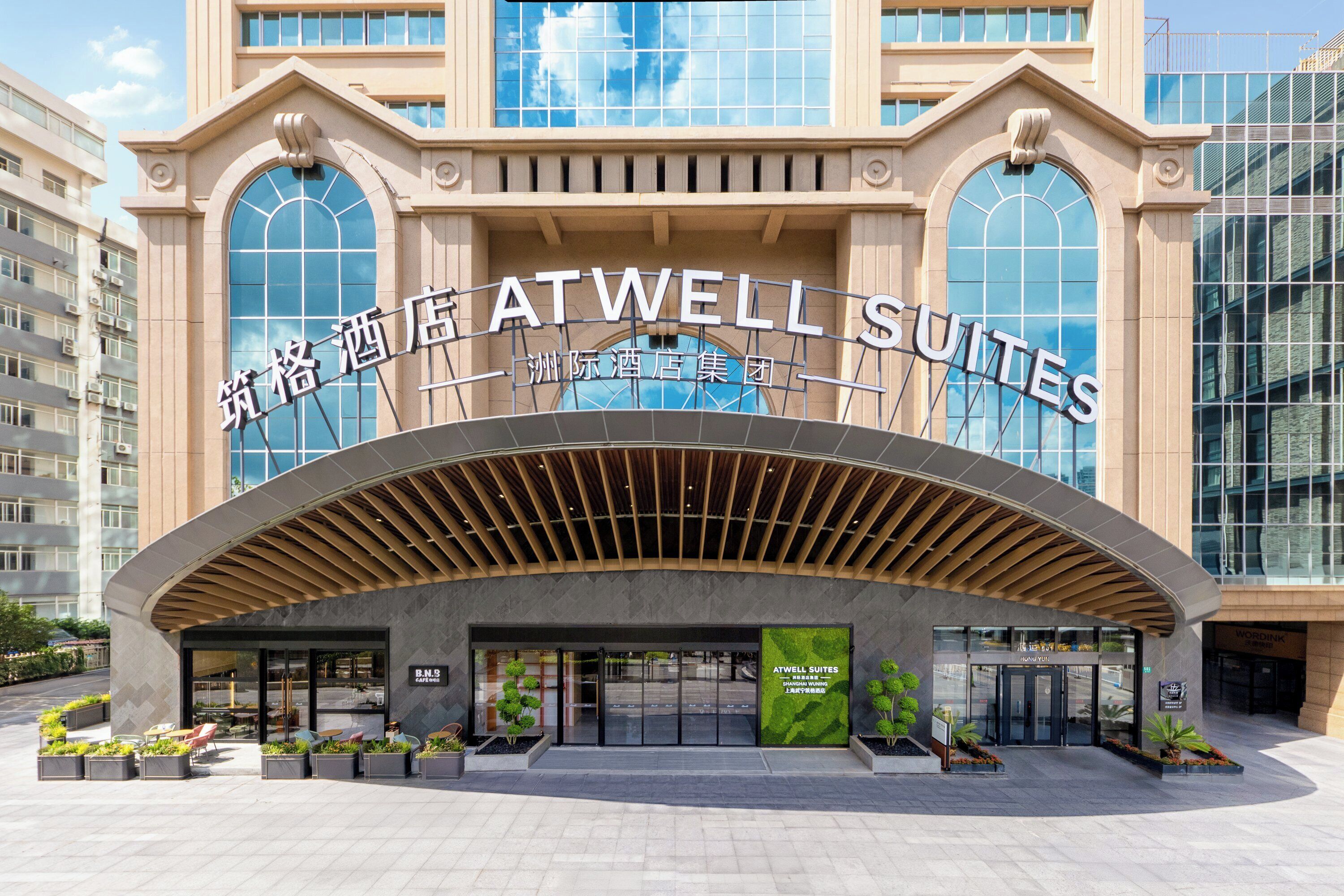 Exterior del hotel Atwell Suites con un diseño arquitectónico moderno, destacando amplias ventanas y una entrada imponente.