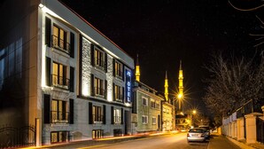 Un hotel con fachada moderna, varios balcones y un cartel llamativo.