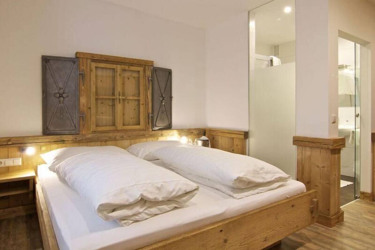 A bedroom with a wooden bed, two nightstands, a mirror, and a wardrobe.