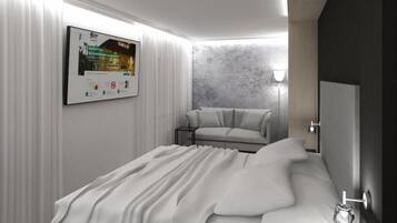 A modern bedroom with a bed, a sofa, a small table, and a wall-mounted poster.
