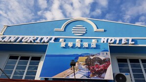 The exterior of Santorini Hotel with a clear blue sky and a large signboard. - Santorini Hotel Melaka (Malacca City)