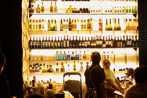 Un bar con estantes llenos de botellas de licor.
