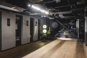 A modern interior with exposed ductwork, wooden flooring, and potted plants.