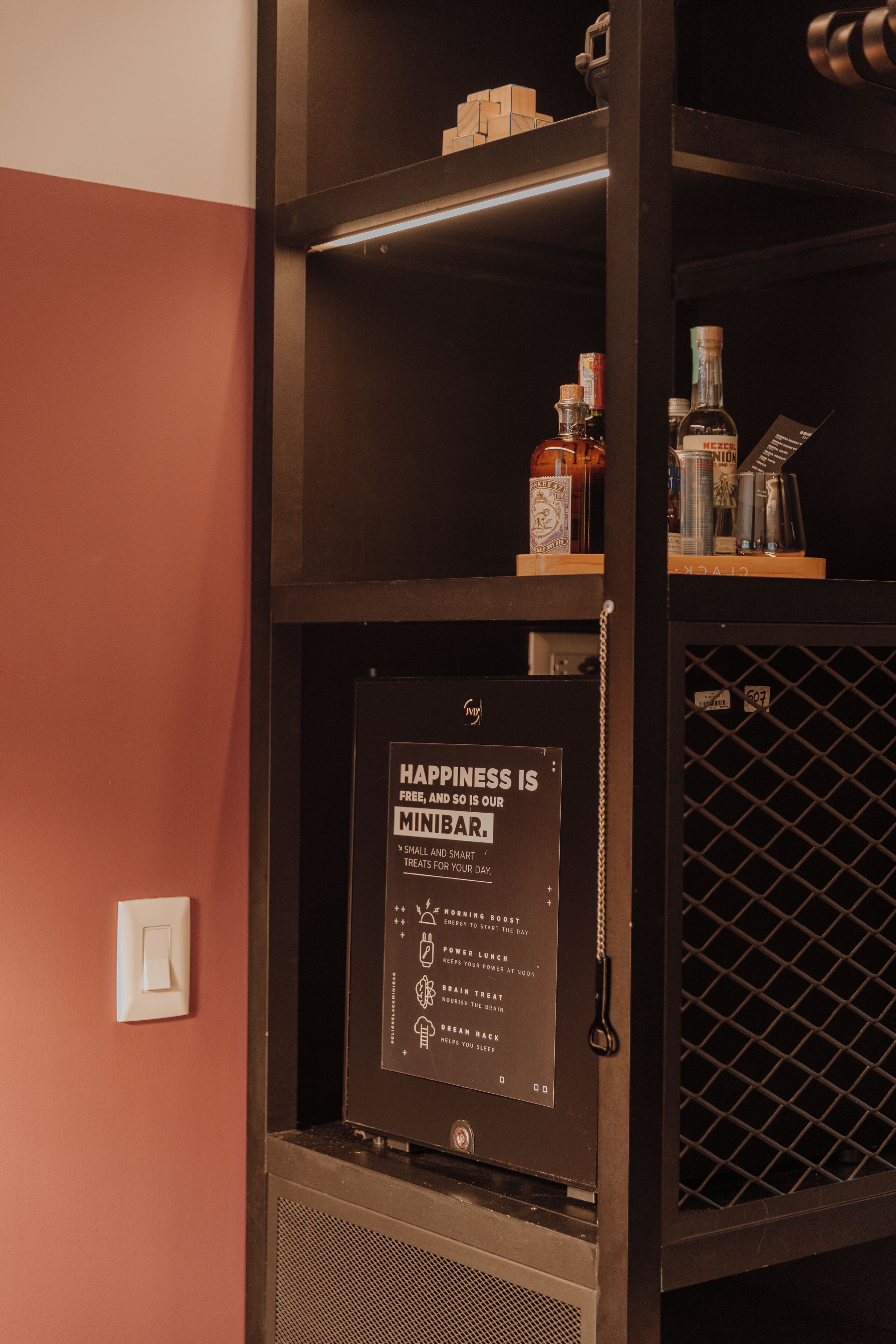 A minibar with a sign stating "Happiness is free, and so is minibar."