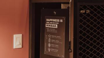 A minibar with a sign stating "Happiness is free, and so is minibar."