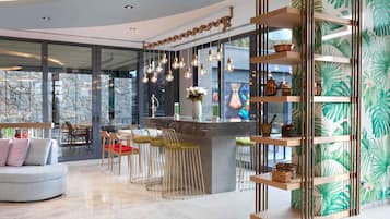 A modern interior with a bar area, seating, and a decorative wall with leaf patterns.