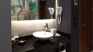 A modern bathroom with a large mirror, a white sink, and a hairdryer mounted on the wall. - ibis Styles Istanbul Atasehir (Istanbul)
