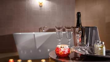 A bar area with a bottle of champagne, glasses, and a tray with bottles.