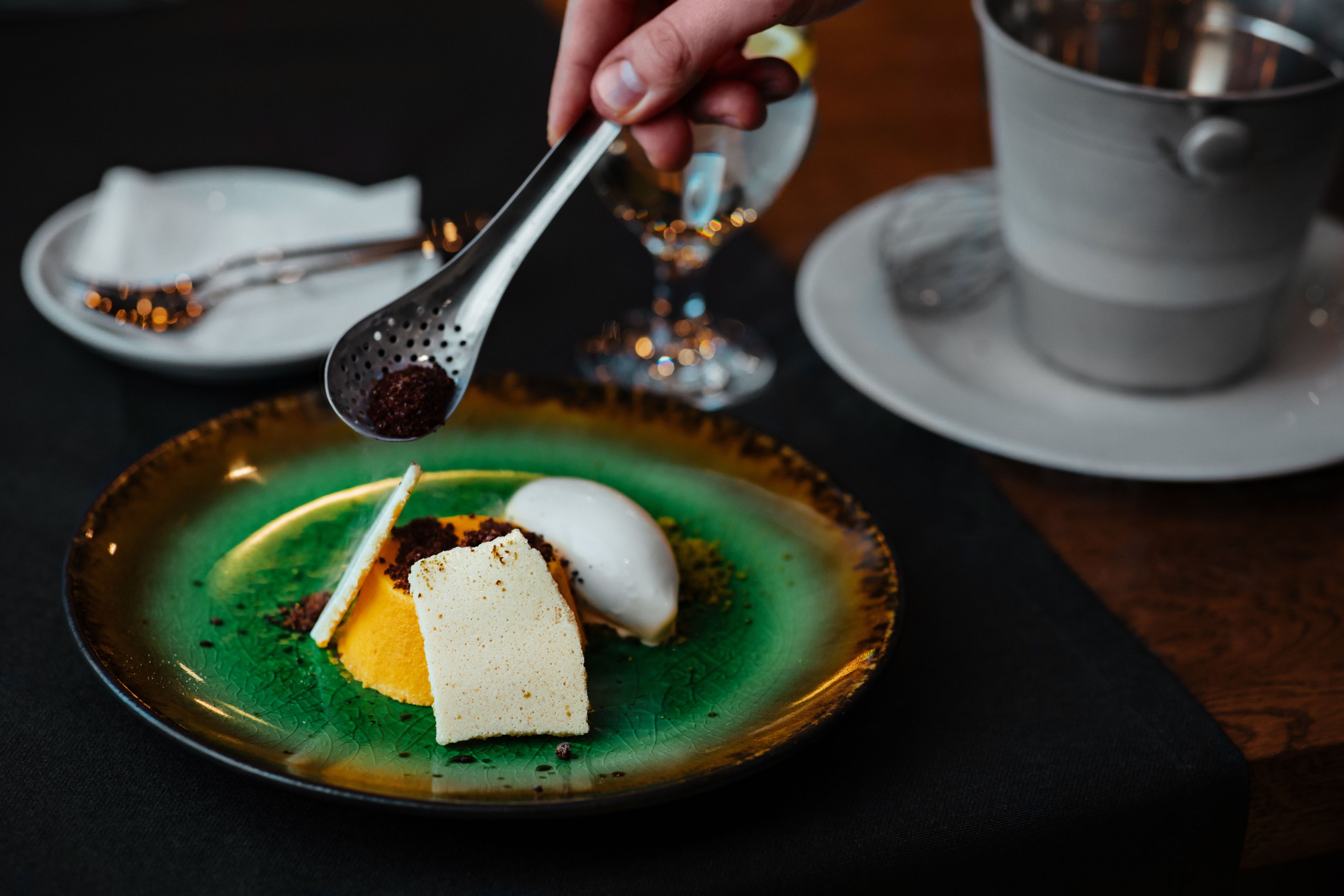 A dessert on a green plate with a spoon.