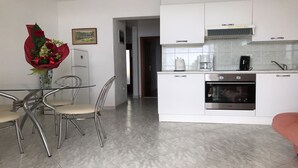 A modern kitchen with white cabinets, a stainless steel oven, and a coffee maker. - Apartments Villa Marija (Seget)