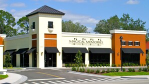 A building with a sign reading "Magical Memories" offering villas, condos, private pools, and Orlando accommodations. - Sunderland Condo at Windsor Hills Resort (Kissimmee)