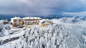 A hotel with multiple floors and a snow-covered landscape. - Taj Theog Resort & Spa, Shimla (Theog)