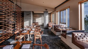 A modern restaurant with wooden furniture, stone walls, and large windows. - Taj Theog Resort & Spa, Shimla (Theog)