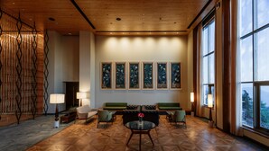 A spacious lobby with a wooden floor, green sofas, a round table, and large windows offering a view. - Taj Theog Resort & Spa, Shimla (Theog)