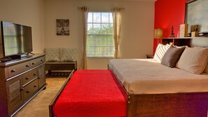A bedroom with a bed, a dresser, a TV, a window with blinds, and a painting of the Eiffel Tower. - Stirling Vacation Home at Solterra (Davenport)