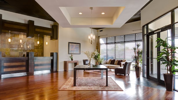 A spacious lobby with a wooden reception desk, a dining area with a table and chairs, and large windows providing natural light. - Kingston Condo at Windsor Palms Resort (Kissimmee)