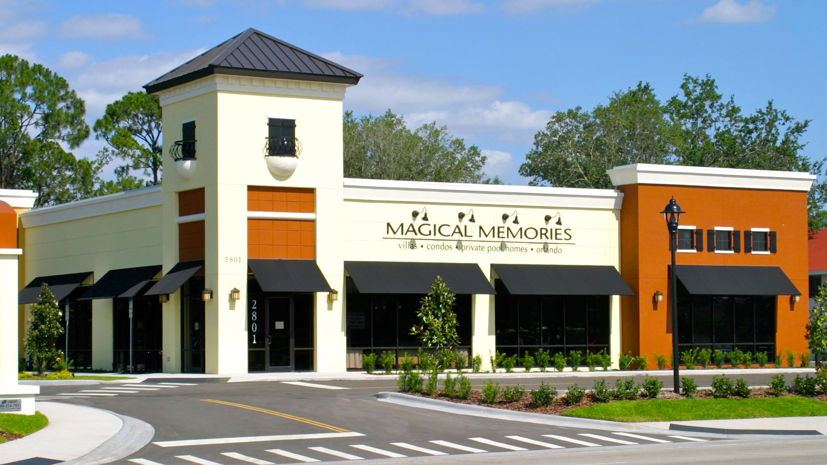 A building with a sign reading "Magical Memories" offering villas, condos, private pools, and Orlando accommodations.