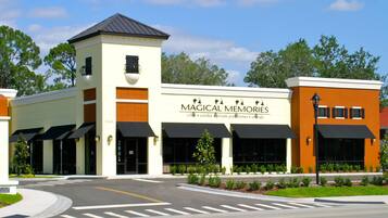 A building with a sign reading "Magical Memories" offering villas, condos, private pools, and Orlando accommodations.