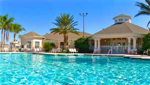 A swimming pool with lounge chairs and palm trees. - Clovelly Condo at Windsor Palms Resort (Kissimmee)