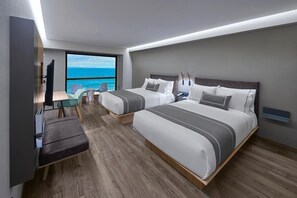 Een moderne hotelkamer met twee bedden, een bureau en een groot raam met uitzicht op de oceaan.