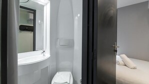 A bathroom with a sink, toilet, and shower. - Easyhotel London Victoria (London)