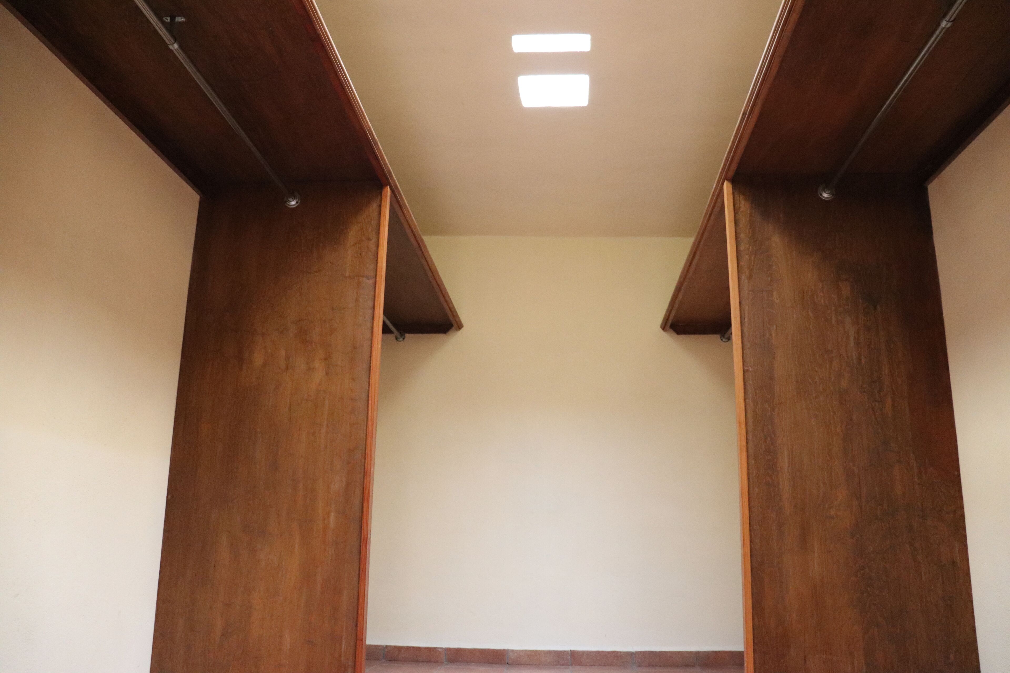 A room with a wooden ceiling structure and a recessed light fixture.