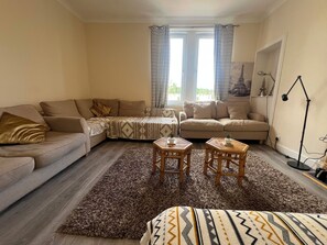A living room with a sofa, two armchairs, a coffee table, and a rug. - Beach & City Access Flat 2 Floors, Full Kitchen near train 7mins (Methil)