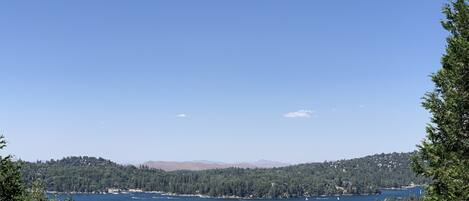Una vista despejada de un lago rodeado de bosque denso y colinas.