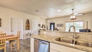 A kitchen with granite countertops, stainless steel sink, and a dishwasher. - Canal-Front Home w/ Boat Dock in Crystal River (Crystal River)