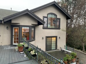 A two-story house with a balcony, large windows, and potted plants. - Bay-view home on a private acre — Pinole (Pinole)