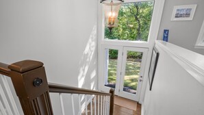 Eine Holzhandrail-Geländer führt zu einer Glastür, die in einen Garten führt.