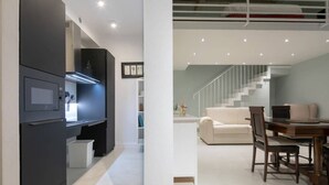 Een moderne keuken met inbouwapparatuur en een eethoek, met een trap naar een hoger gelegen verdieping.