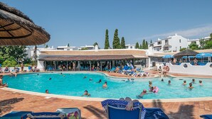 A swimming pool area with multiple pools, lounge chairs, and umbrellas. - Jasmine Apartment, AC, Pool, Balcony (Albufeira)