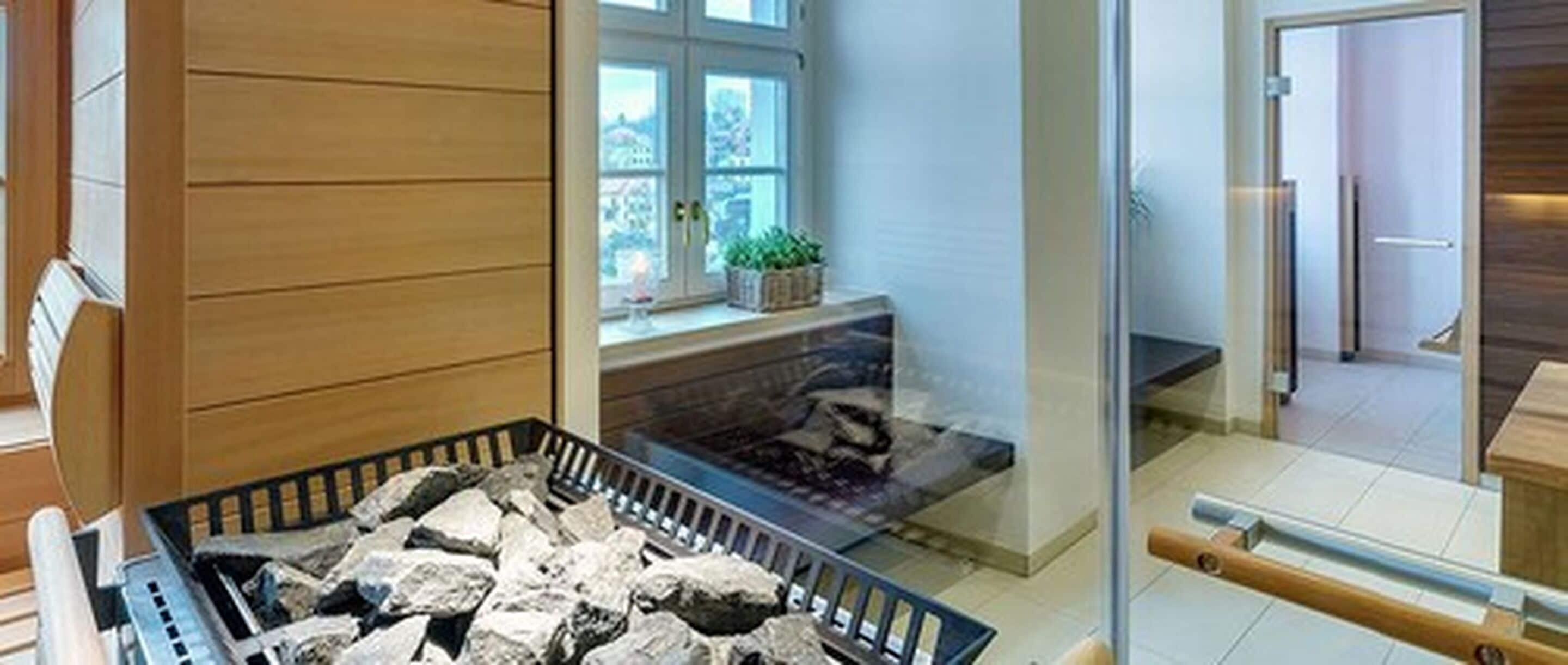 A modern interior with a stone fireplace, wooden paneling, and a view through a glass door.