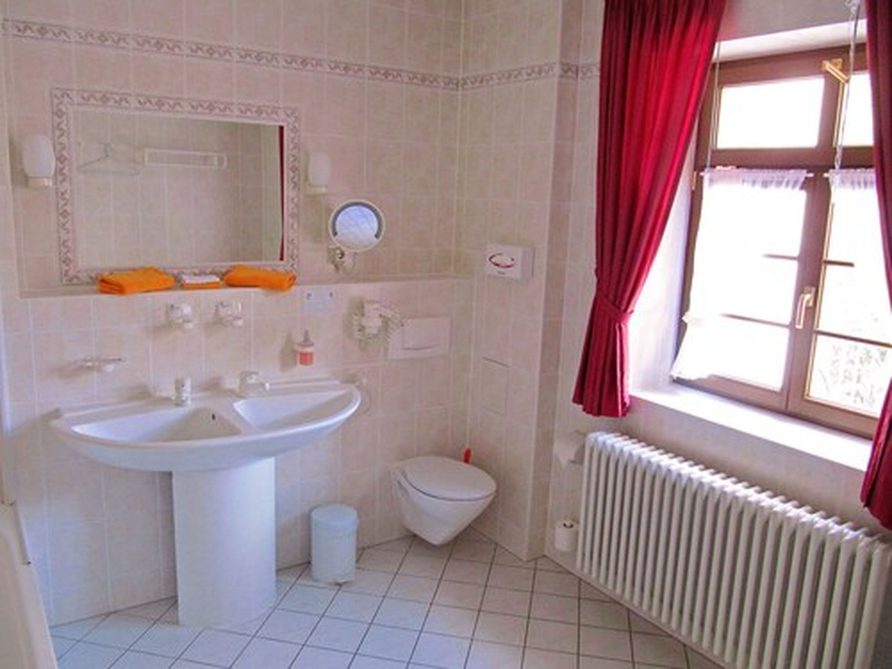 Une salle de bain équipée d’un lavabo, de toilettes et d’un radiateur.