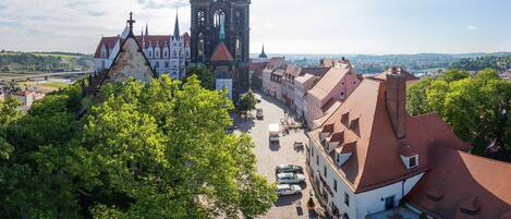 A historic town with a prominent Gothic church, cobblestone streets, and lush greenery.