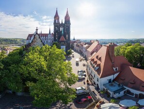 Une ville historique qui se distingue par son imposante église gothique, ses rues pavées et sa végétation luxuriante.