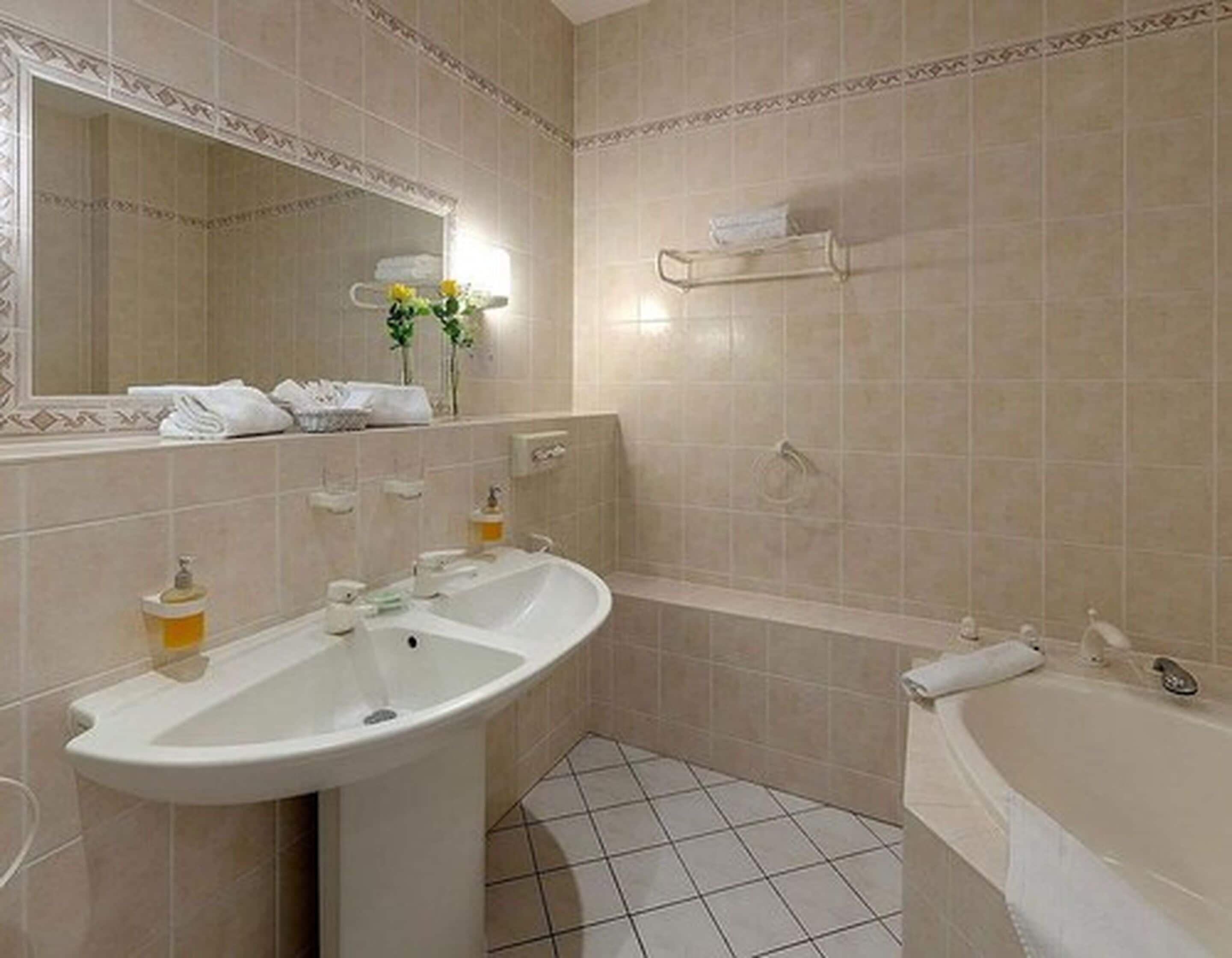Un baño con dos lavamanos, un espejo y una bañera.