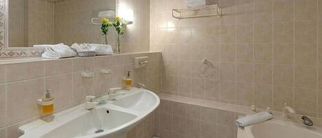 Un baño con dos lavamanos, un espejo y una bañera.