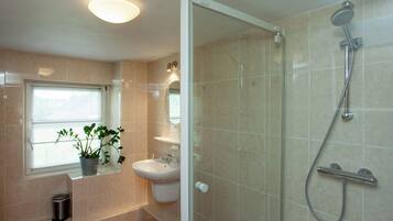 Huis | Badkamer | Een douche, pantoffels, handdoeken